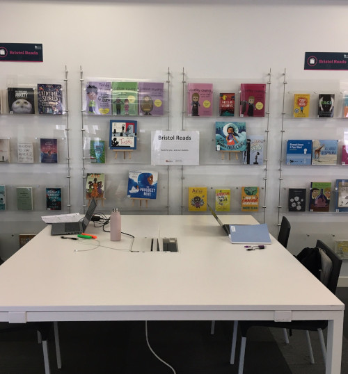 View of desk in use in front of a Bristol Reads display